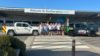 A group of people standing outside Southampton Airport. They are wearing cycling jerseys.
