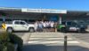 A group of people standing outside Southampton Airport. They are wearing cycling jerseys.