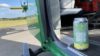 A can of yellow and green IPA in the open door of a helicopter. The IPA is in support of the Hampshire and Isle of Wight Air Ambulance.