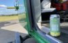 A can of yellow and green IPA in the open door of a helicopter. The IPA is in support of the Hampshire and Isle of Wight Air Ambulance.