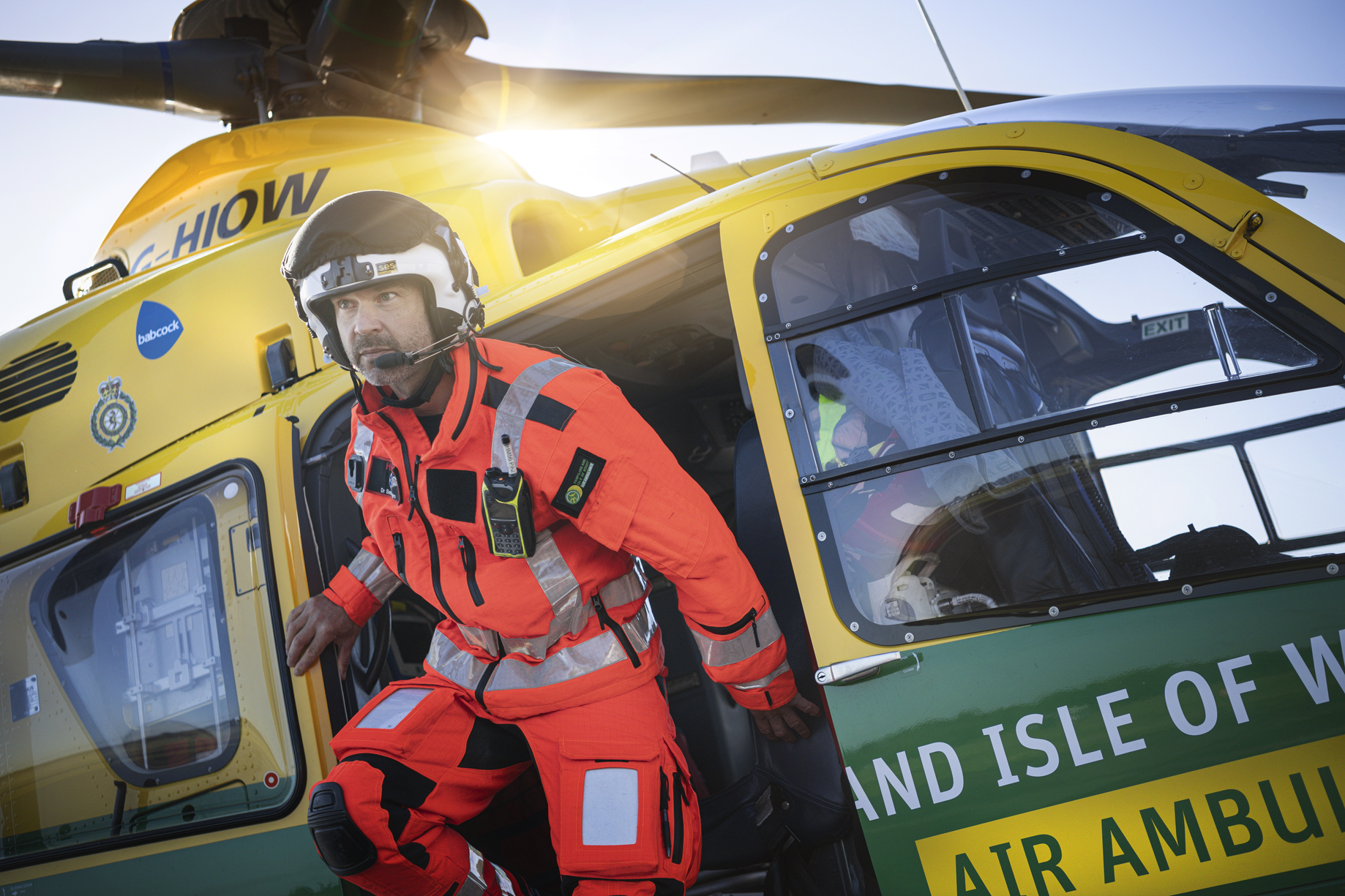 HEMS Doctor Ben Siggers exiting the helicopter wearing his flight suit and flight helmet