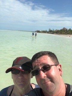 A man and a lady on the beach with the sea in the bacnground