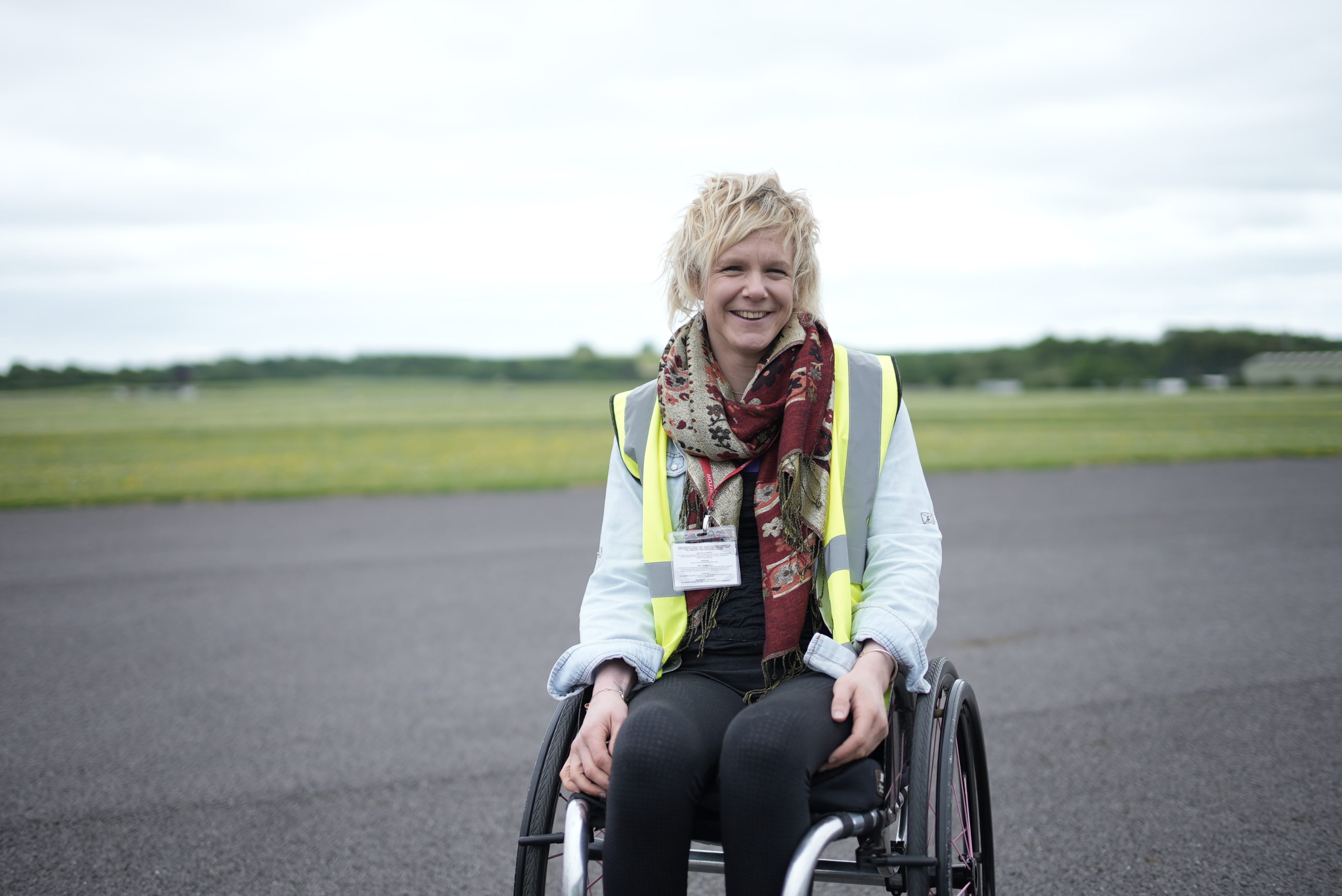 A lady in a wheelchair smiling at the camera