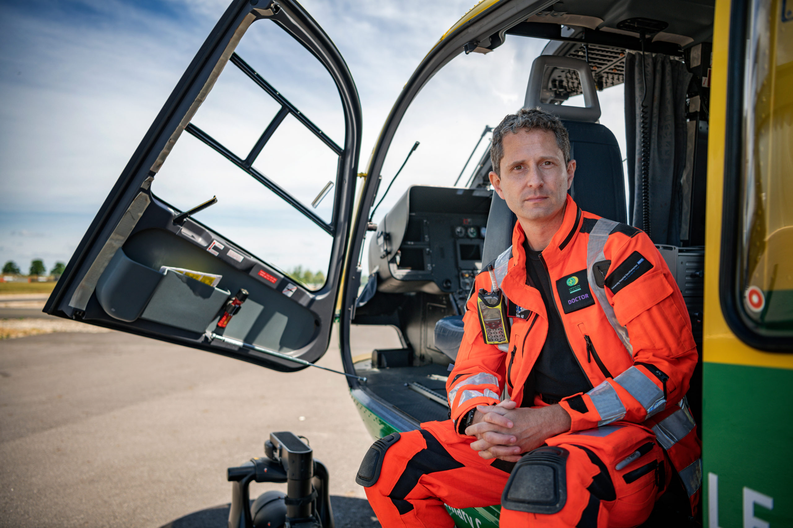 A man sitting in a helicopter looking at the camera