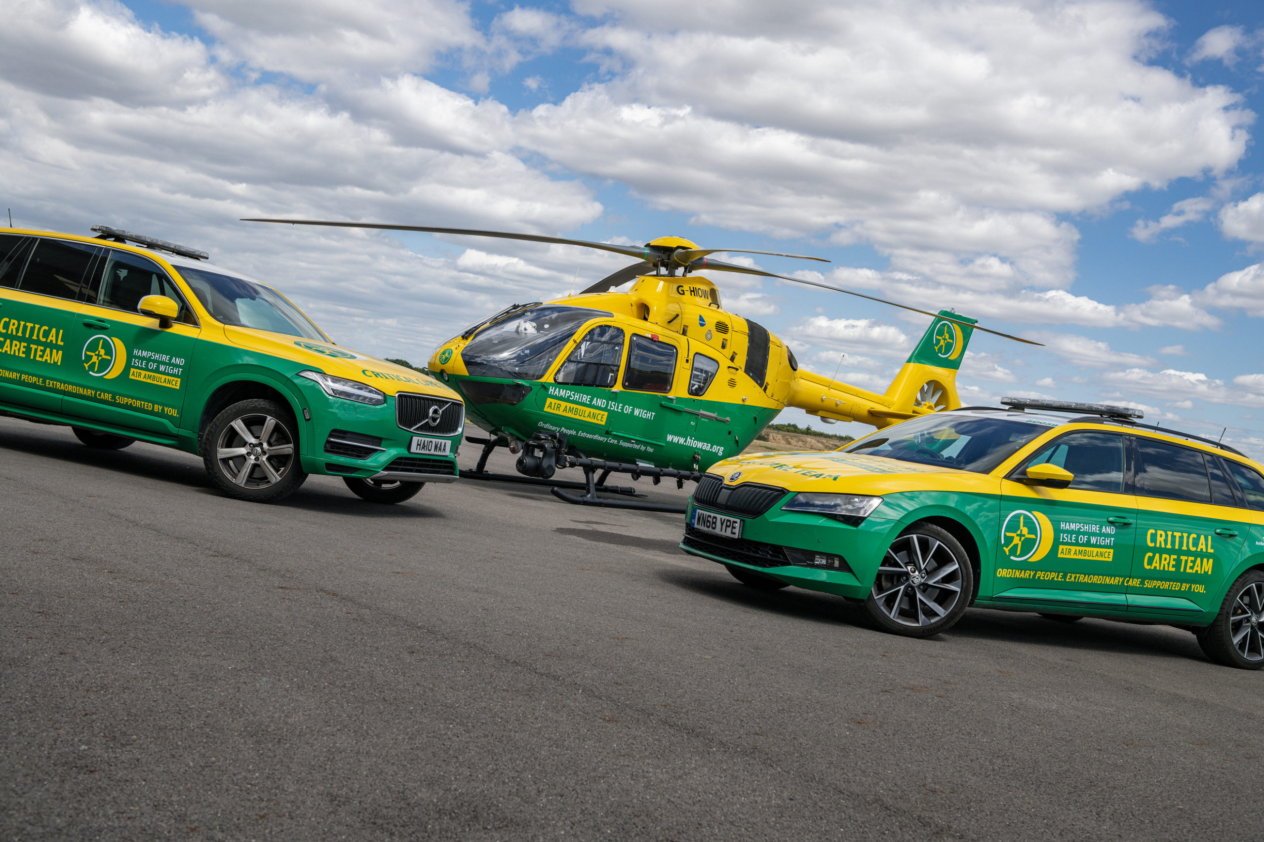 Two emergency road ambulance cars and a helicopter