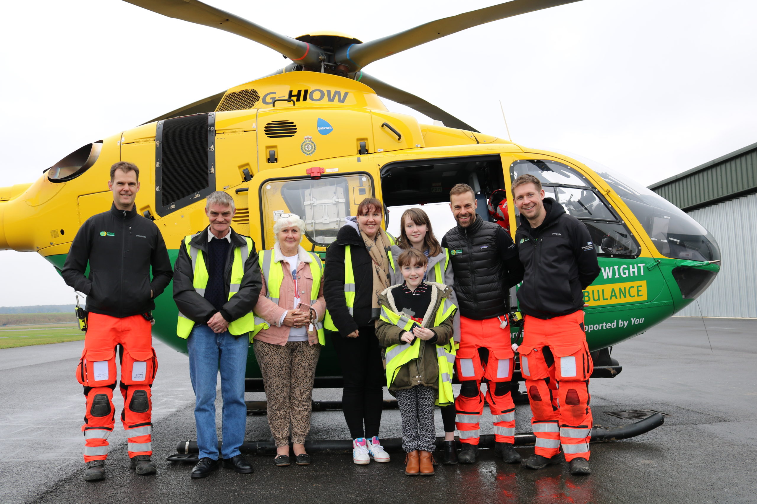 People stood in front of the doors of a helicopter