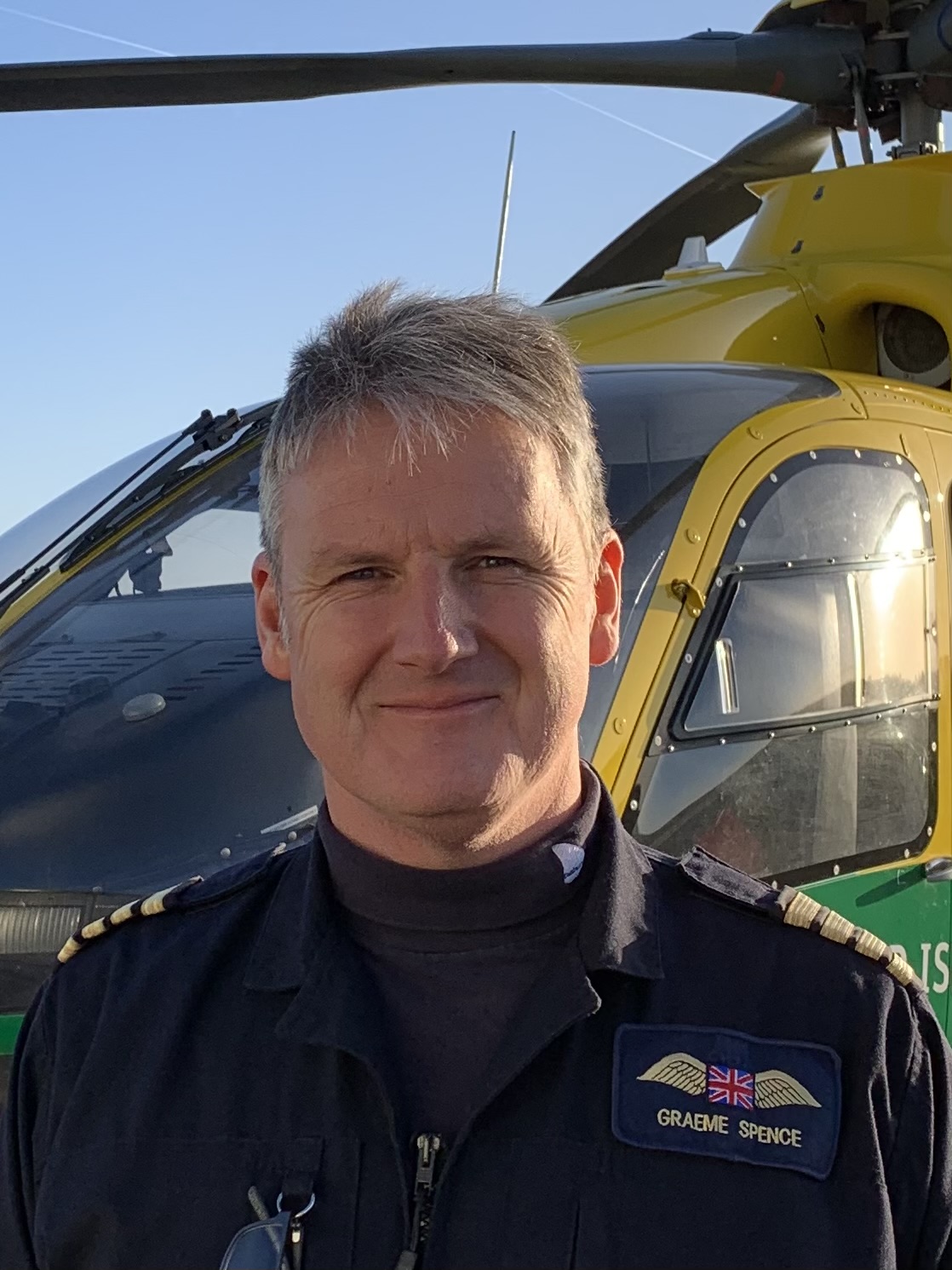 Pilot Graeme Spence stands in front of the helicopter