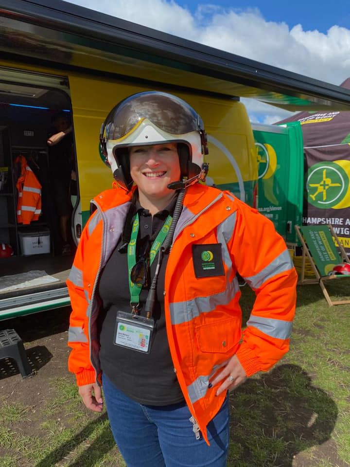 A HIOWAA volunteer wearing an orange flight jacket and flight helmet.