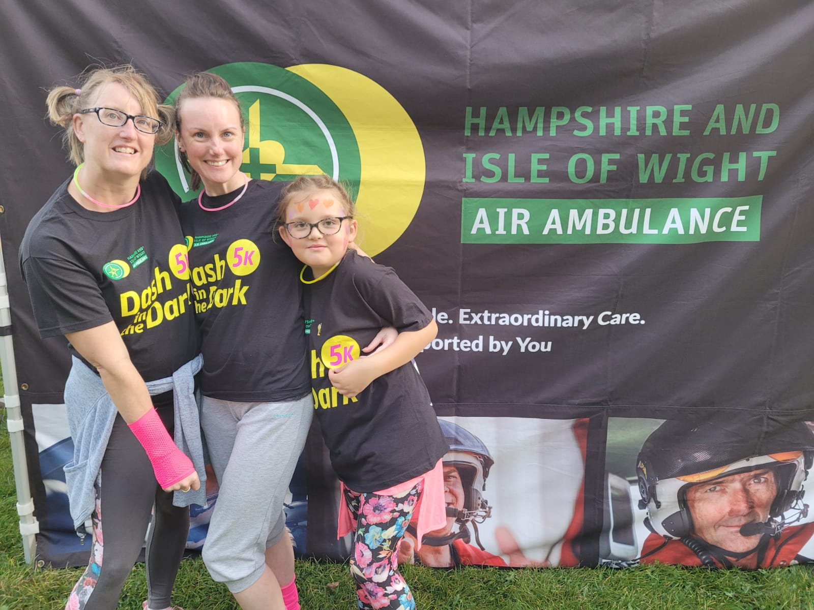 Three people wearing HIOWAA branded Dash in the Dark T-shirts.