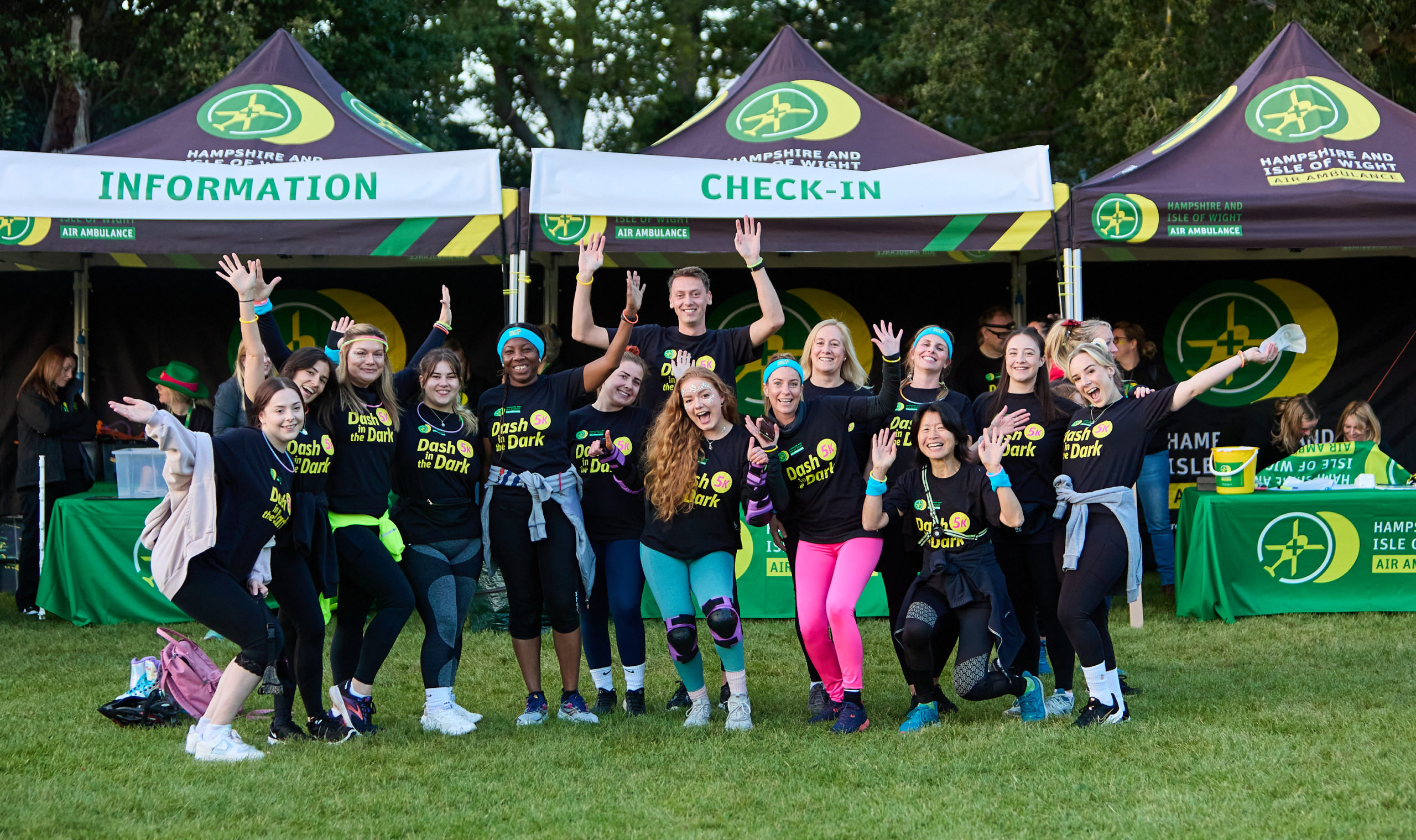 A big group of people wearing matching T-shirts and neon accessories