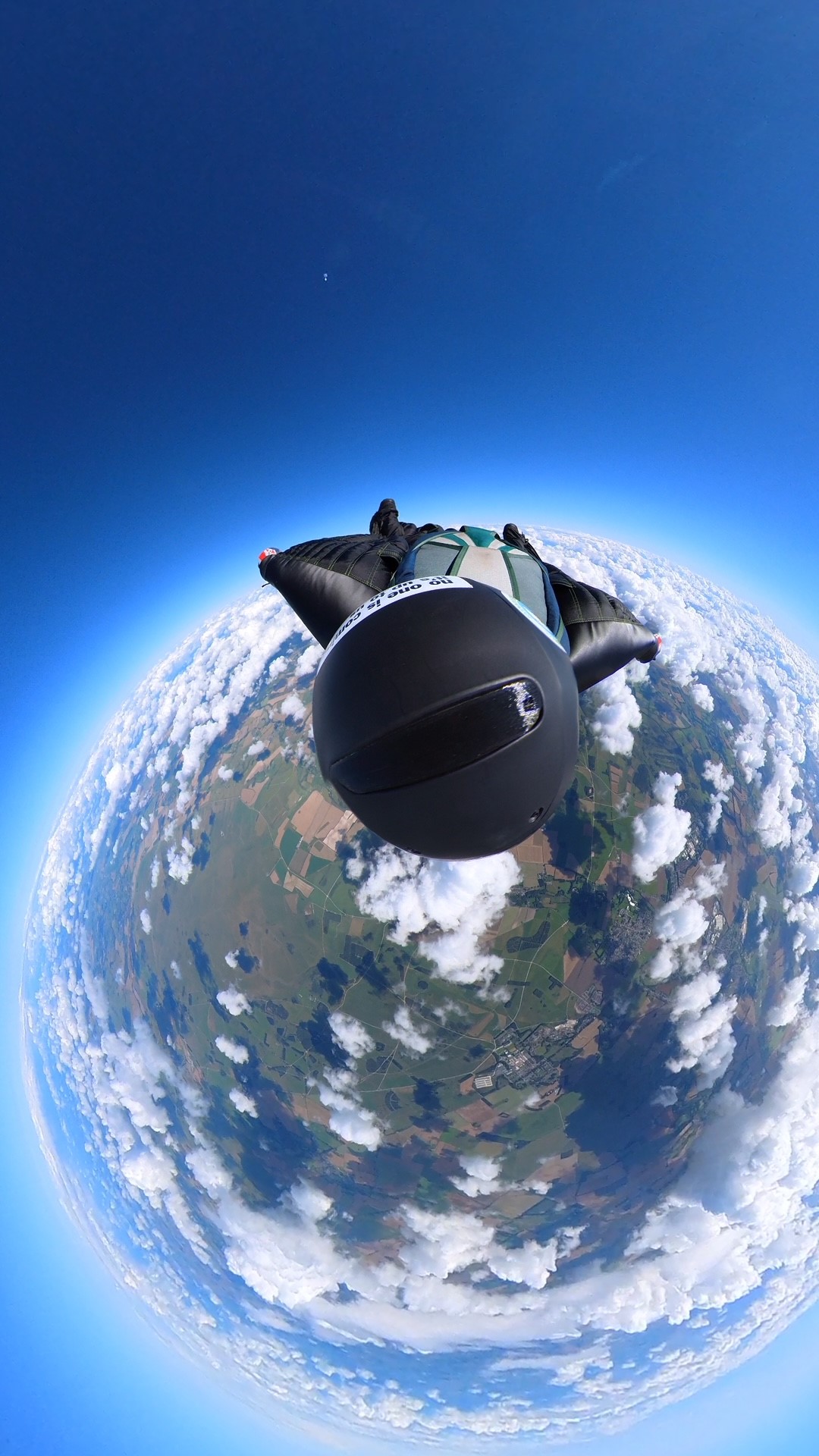 A skydiver in freefall with the curvature of the Earth pictured below him.