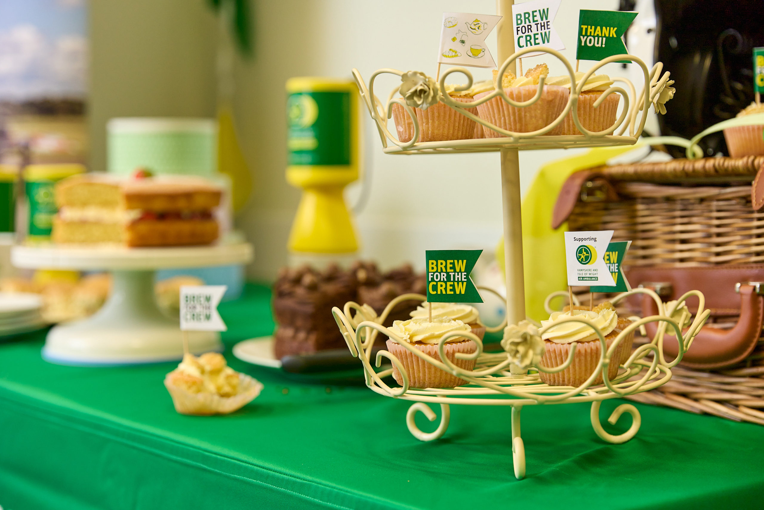 A table with cakes and collection pots at a Brew for the Crew event.