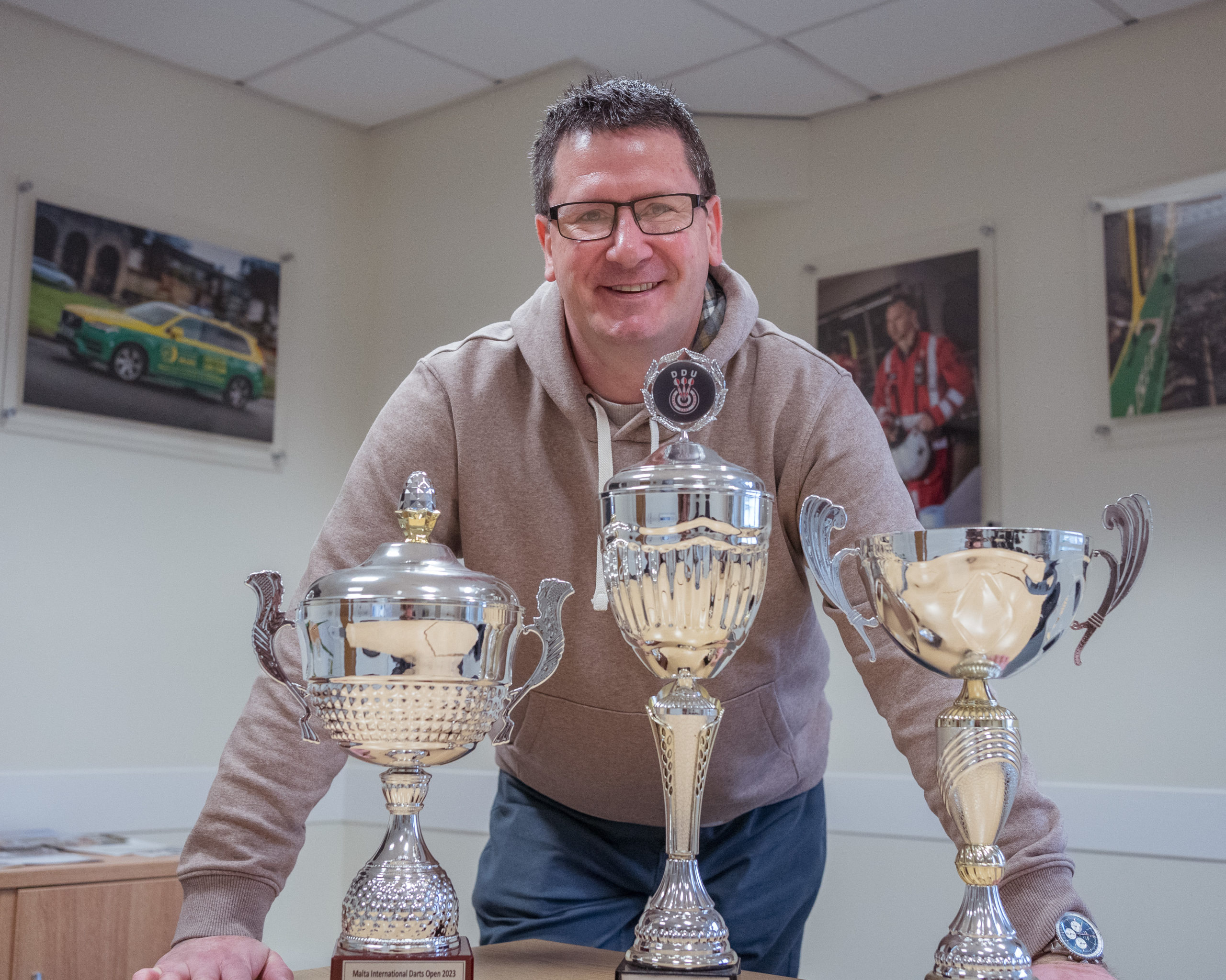 Steve stood behind three large trophies