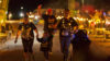 Four people draped in lights on a fun run - one lady pushing a child's buggy