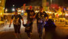 Four people draped in lights on a fun run - one lady pushing a child's buggy