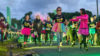 A group of people with multi-coloured tutus and glow sticks on a charity fun run