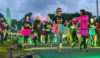 A group of people with multi-coloured tutus and glow sticks on a charity fun run