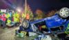 An upturned car with emergency service personnel at a training simulation