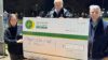 Three people stood beside a large cheque to be donated to the air ambulance