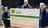 Three people stood beside a large cheque to be donated to the air ambulance
