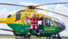 Teddy Medic mascot star jumping in front of the helicopter.
