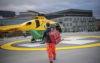 A HEMS doctor walking across a helipad back to a helicopter