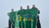 Four Hampshire Police Officers holding a Hampshire and Isle of WIght Air Ambulance flag.