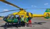 Four people standing in front of a helicopter. Two of the people are part of the Hampshire and Isle of Wight Air Ambulance crew. The other two are representatives from Paultons Park.