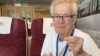 A man sat in a restaurant or diner with a burger and chips and a pint of beer