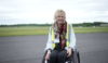 A lady in a wheelchair smiling at the camera