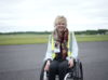 A lady in a wheelchair smiling at the camera