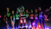 A group of people in a line with a teddy bear mascot