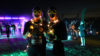 Two people in darkness wearing glow sticks and lights