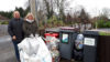 A man and a woman stood next to recycling bins